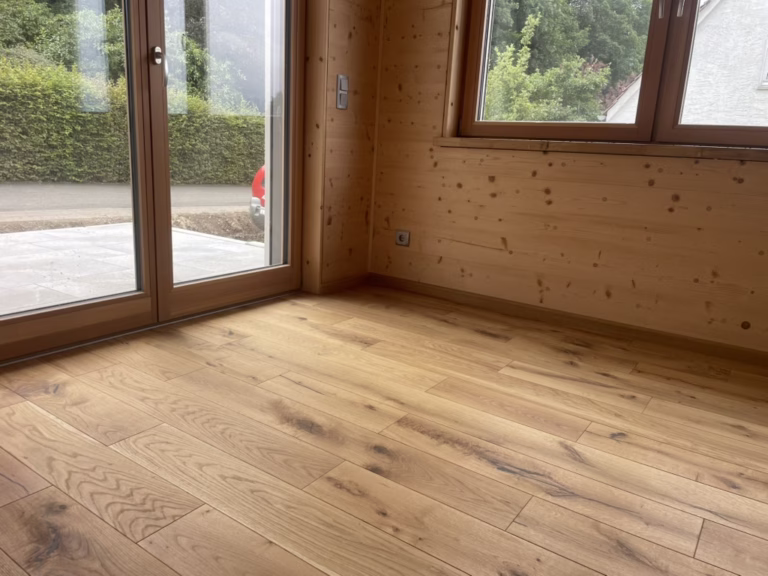 Home 23 Holzboden vor einer großen Terrassentür und einem Fenster mit passenden Randleisten