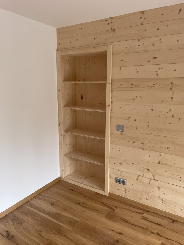 Home 22 Offenes Holzregal mit passgenauen Regalböden in einer holzverkleideten Wandnische