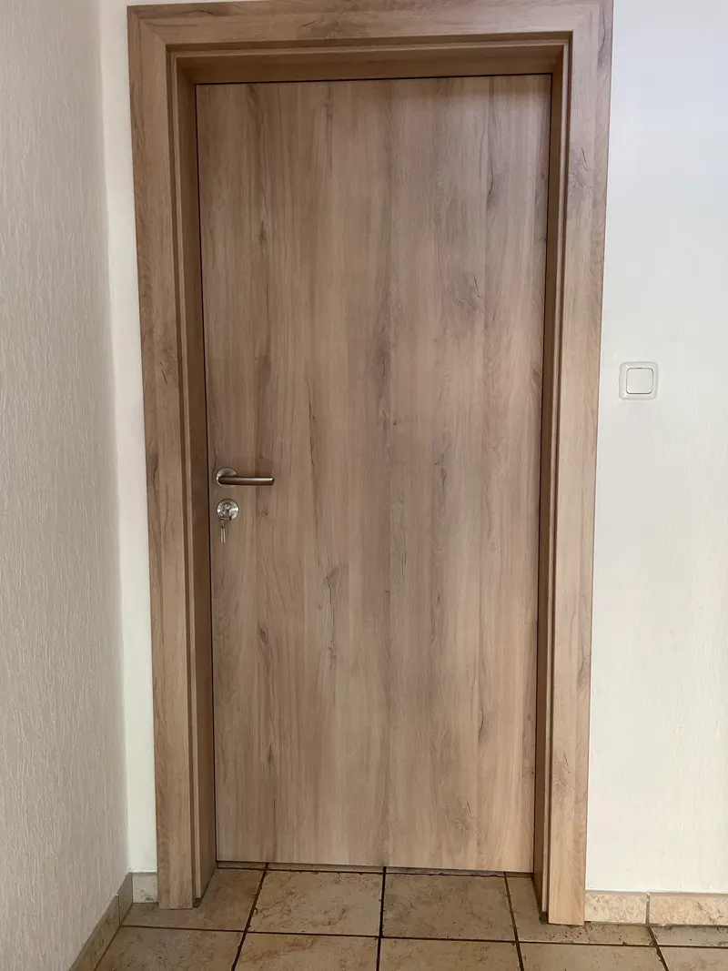 Geschlossene Innentür mit markanter Holzoptik und passender Zarge