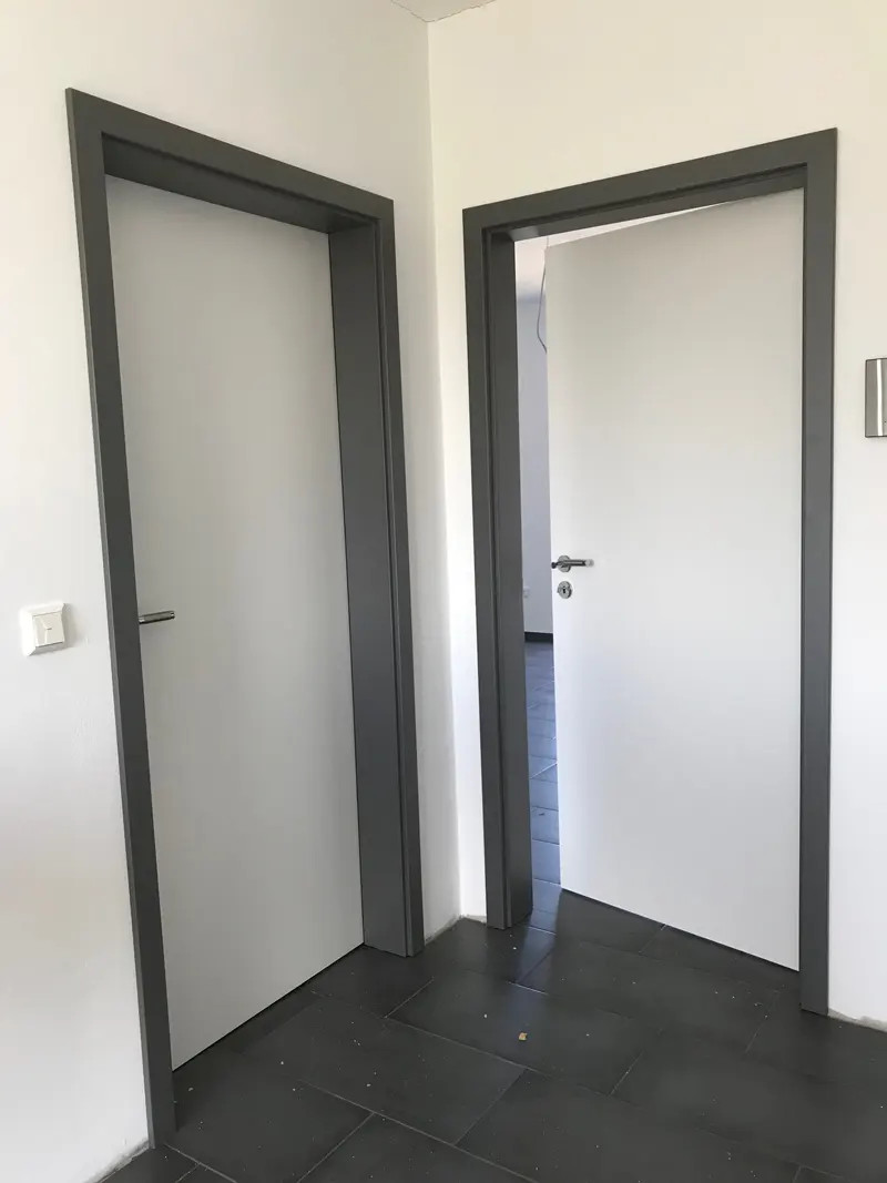 Die passende Türzarge: Wandstärke, Bekleidung und Türblatt zusammen planen 1 Helle Innentüren mit dunkelgrauen Zargen in einem hellen Flur