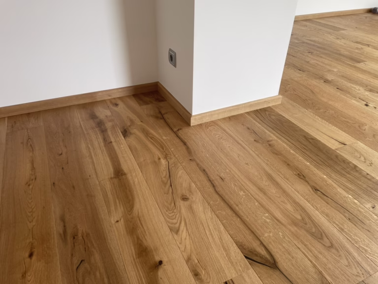 Home 15 Detail eines Holzbodens mit passender Sockelleiste und sauber ausgeführten Anschlüssen an Wand und Ecke